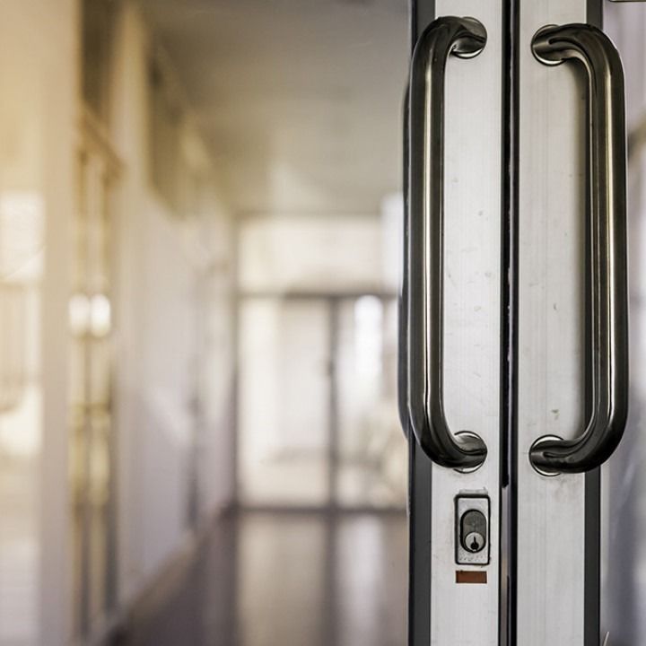 Glass office doors with black handles in a bright hallway