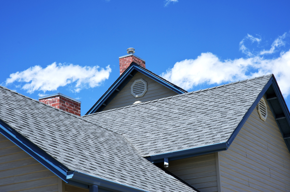 A house with a gray roof and a chimney on top of it.