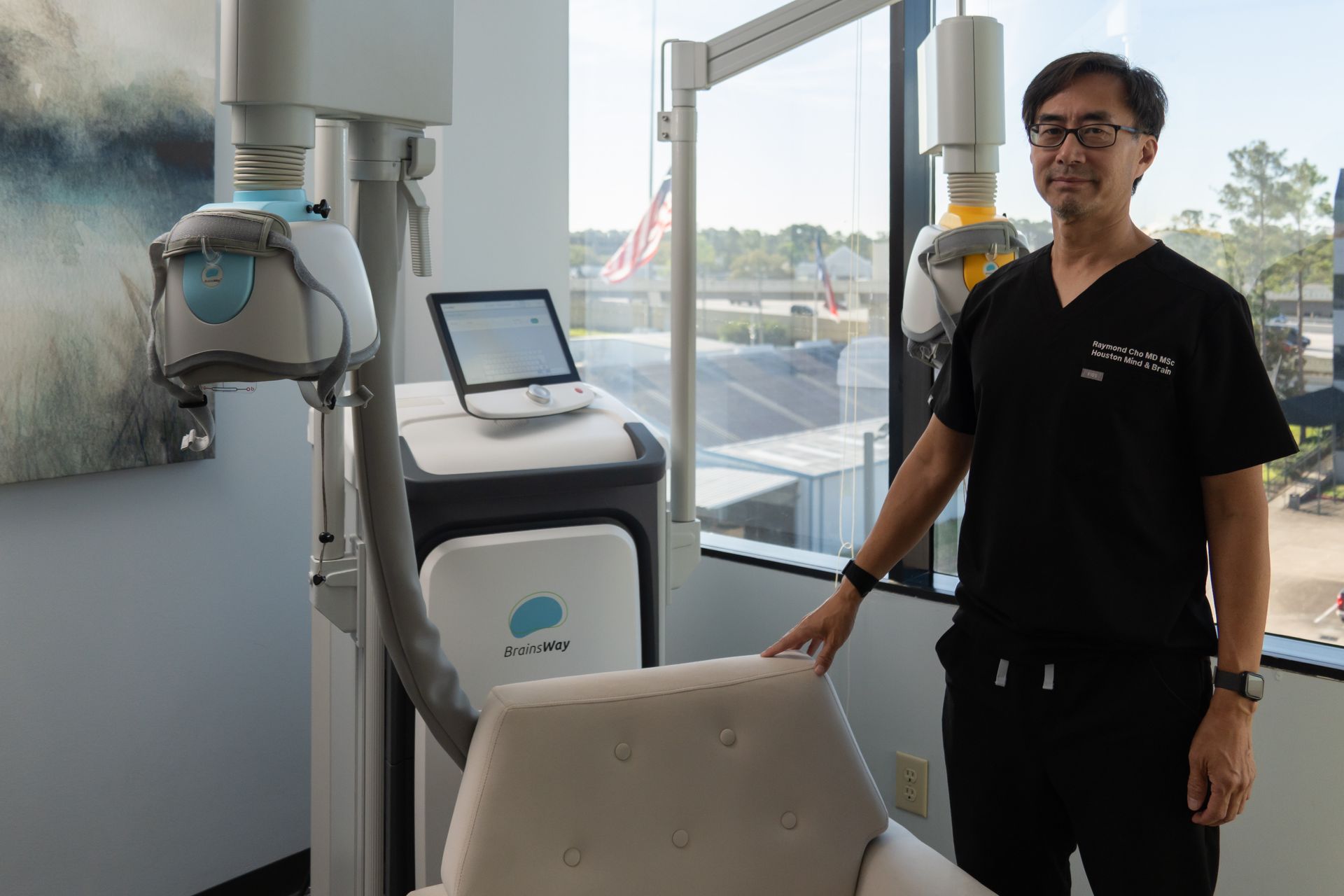 Person standing beside a dental X-ray machine in a bright clinic room