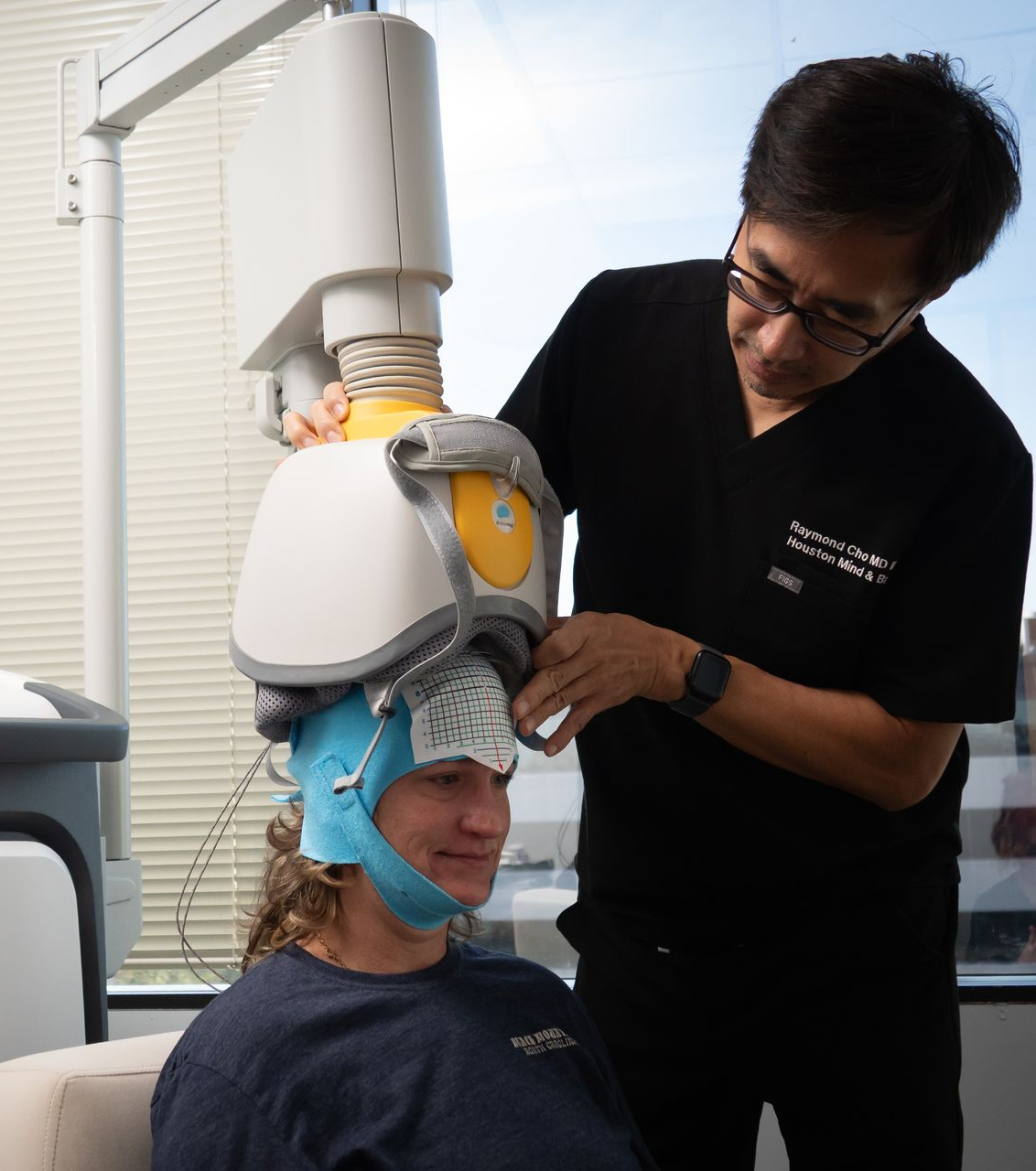 Person receiving a guided relaxation or therapy session with a head-mounted device and assistant adjusting it