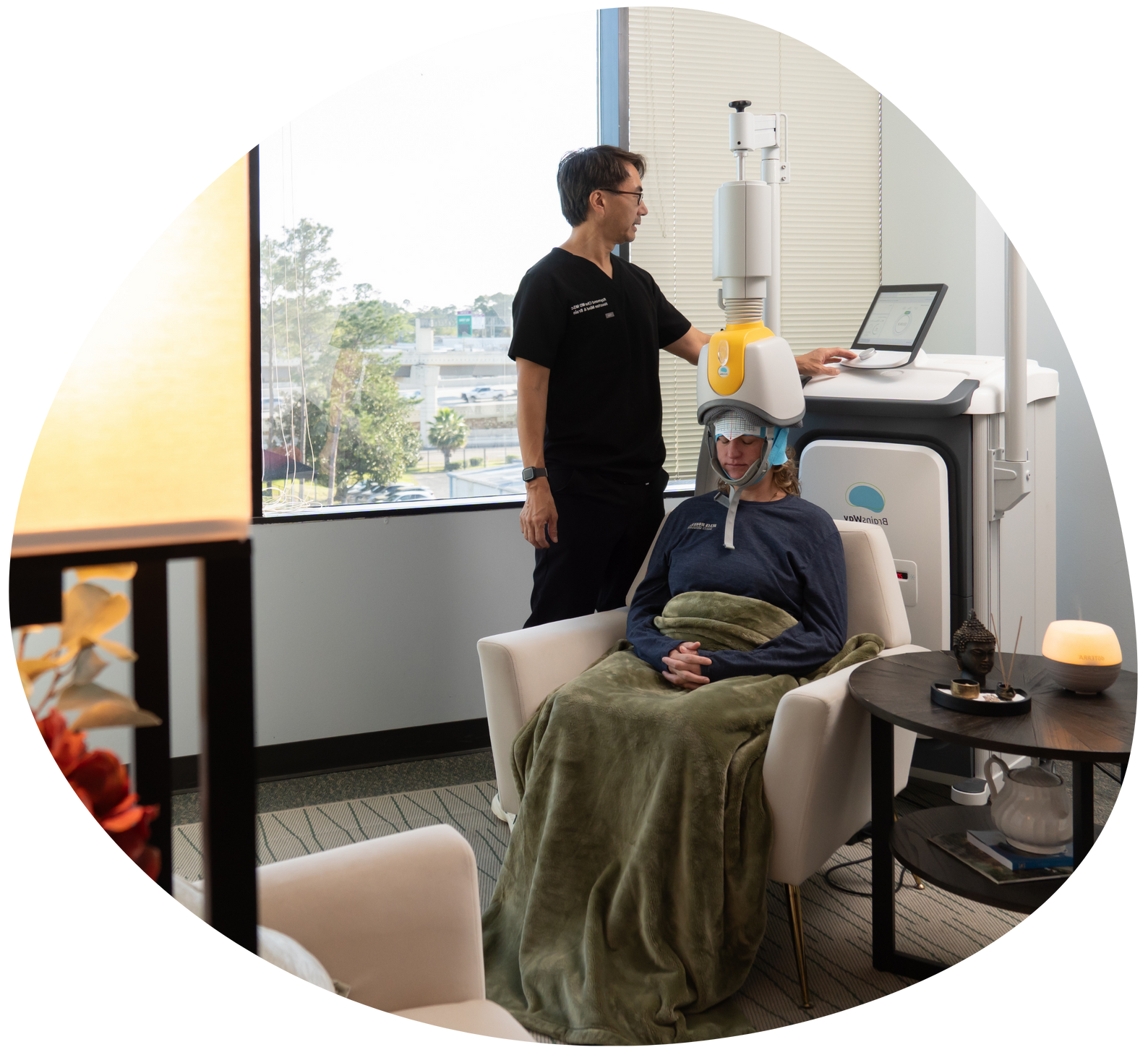 Patient receiving an at-home dental treatment while a clinician stands nearby in a bright room