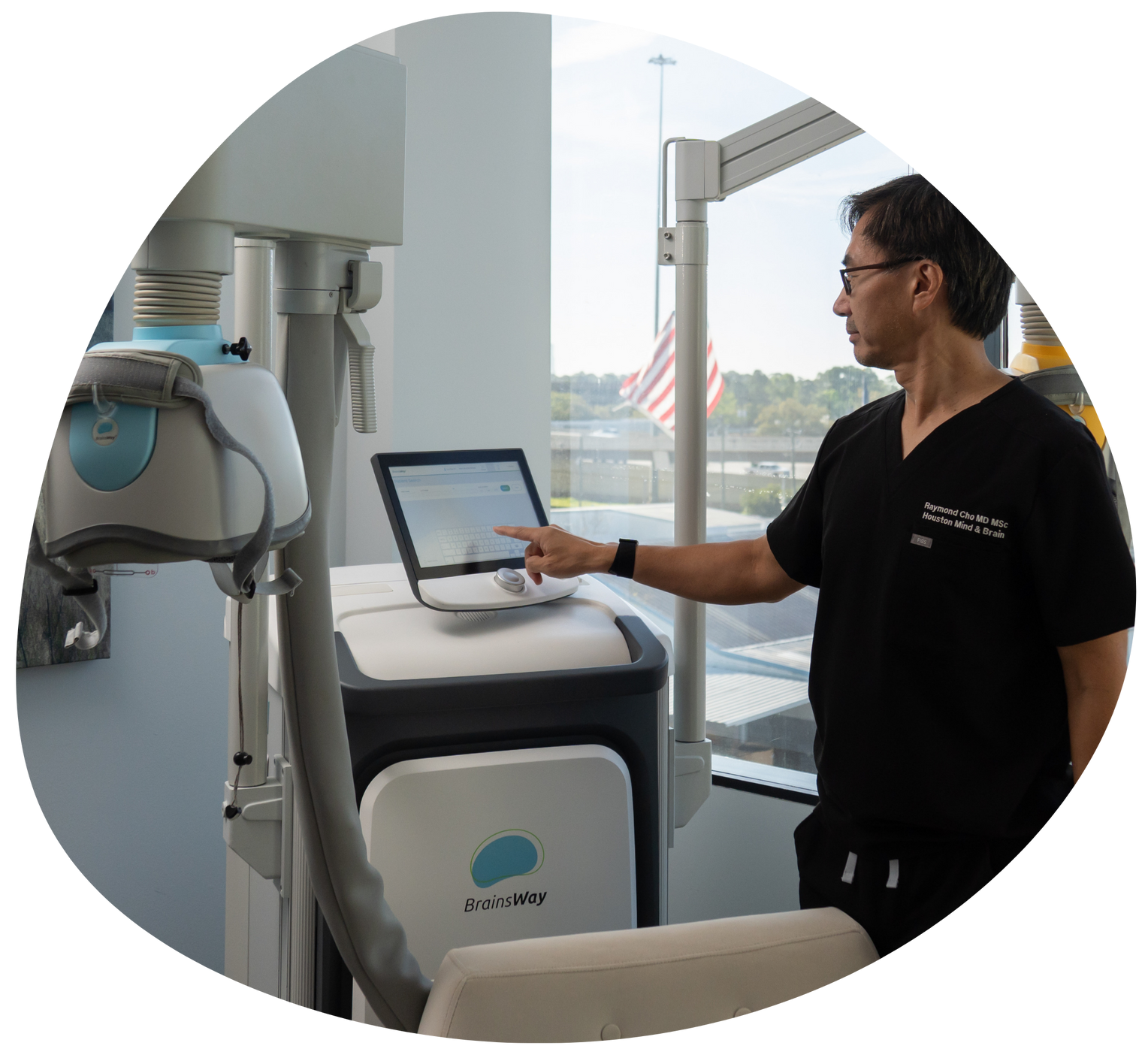 Technician points at a touchscreen on a medical device in a bright hospital room.