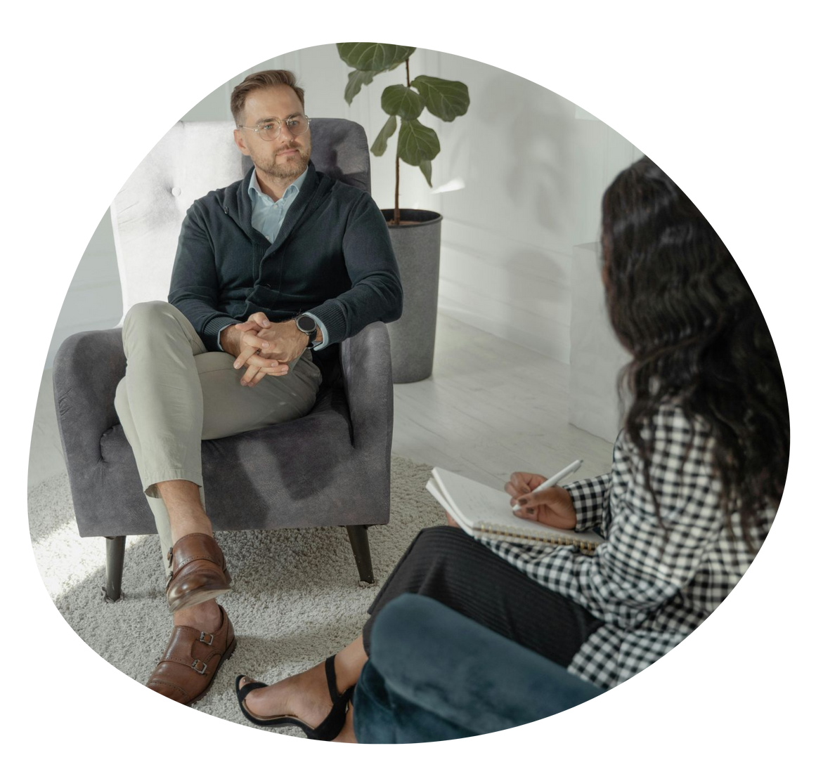 Counselor and client in a bright office, seated and talking during a therapy session.