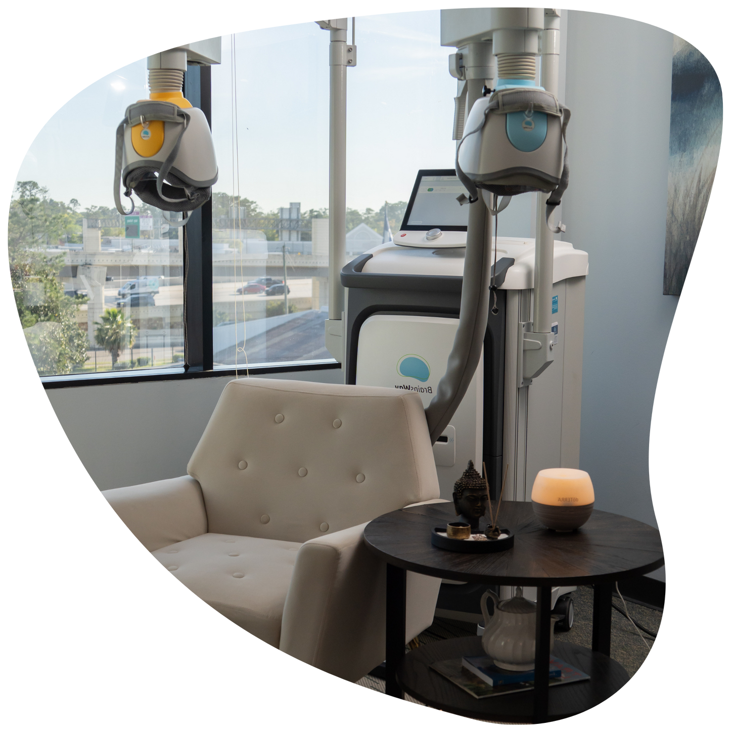 Modern lounge with two robotic arms, a sofa, table, and laptop by large windows