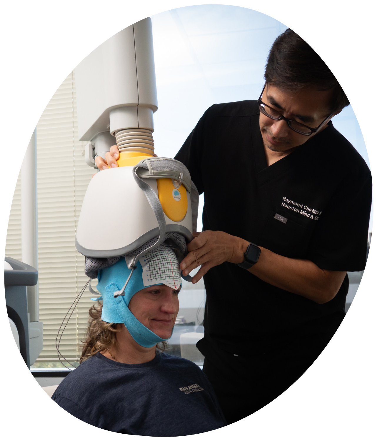 Technician fitting a medical helmet on a patient in a clinic, with a supportive hand on the shoulder