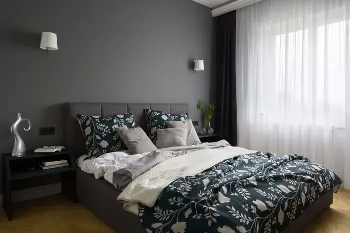 A bedroom with a bed , nightstands , curtains and a window.