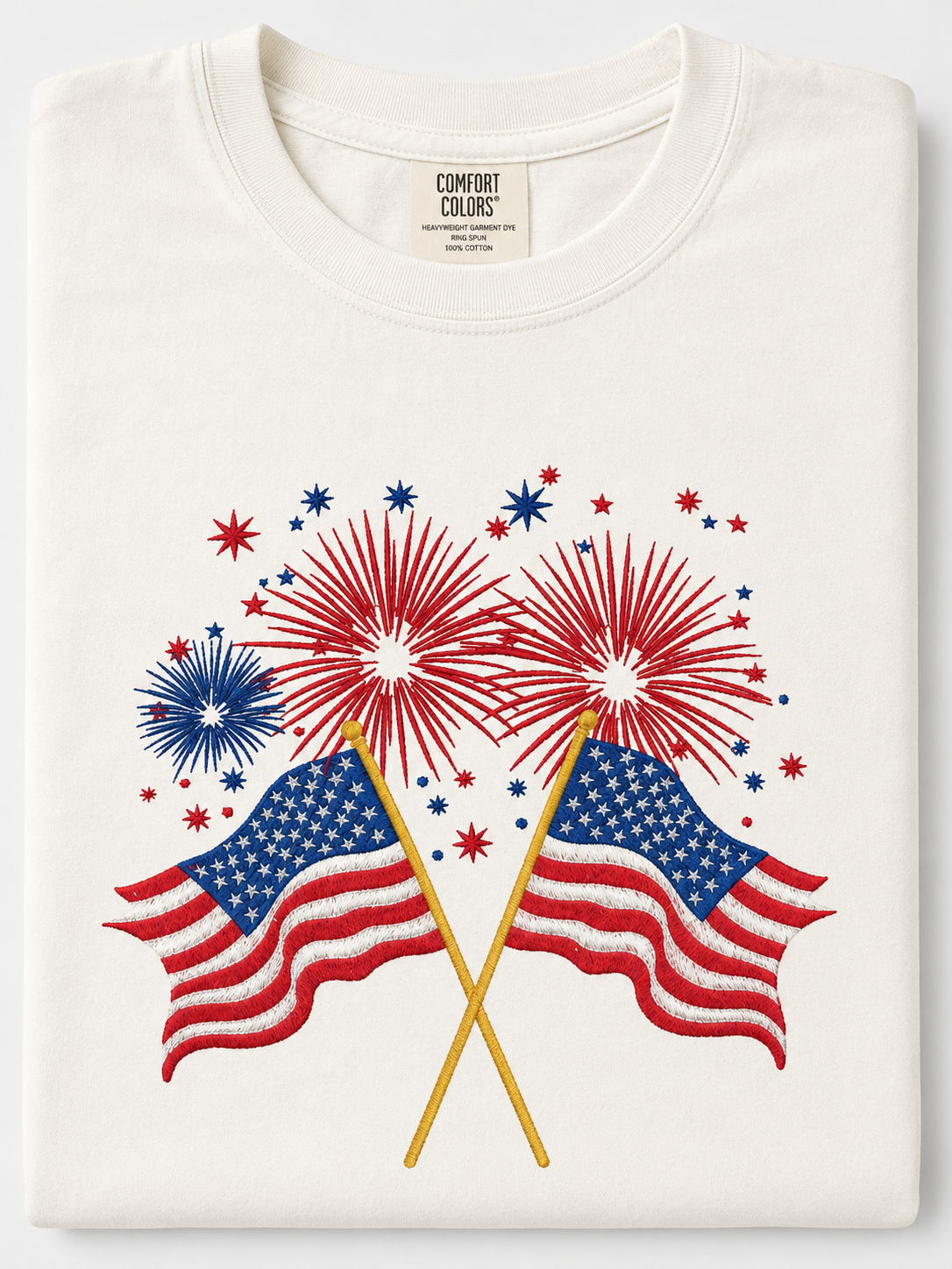 Man in white T-shirt with American flag and fireworks graphic, standing outdoors and smiling in a cap