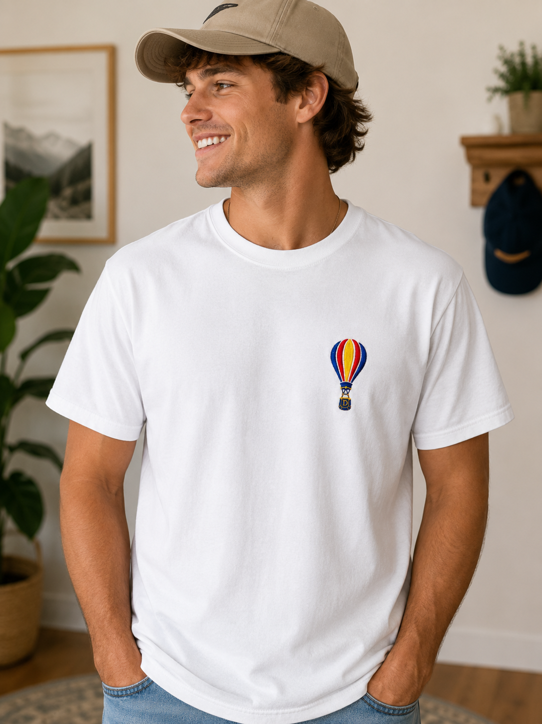 Man wearing a white graphic T-shirt with colorful balloon design, seen from behind in a room.