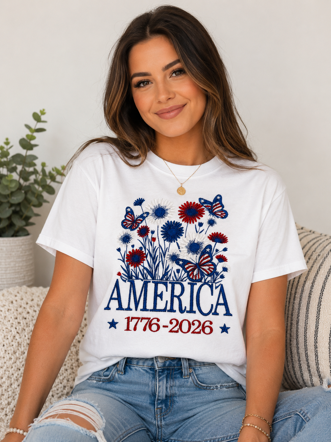 Woman wearing a white patriotic “America 1776–2026” T-shirt with blue and red floral print