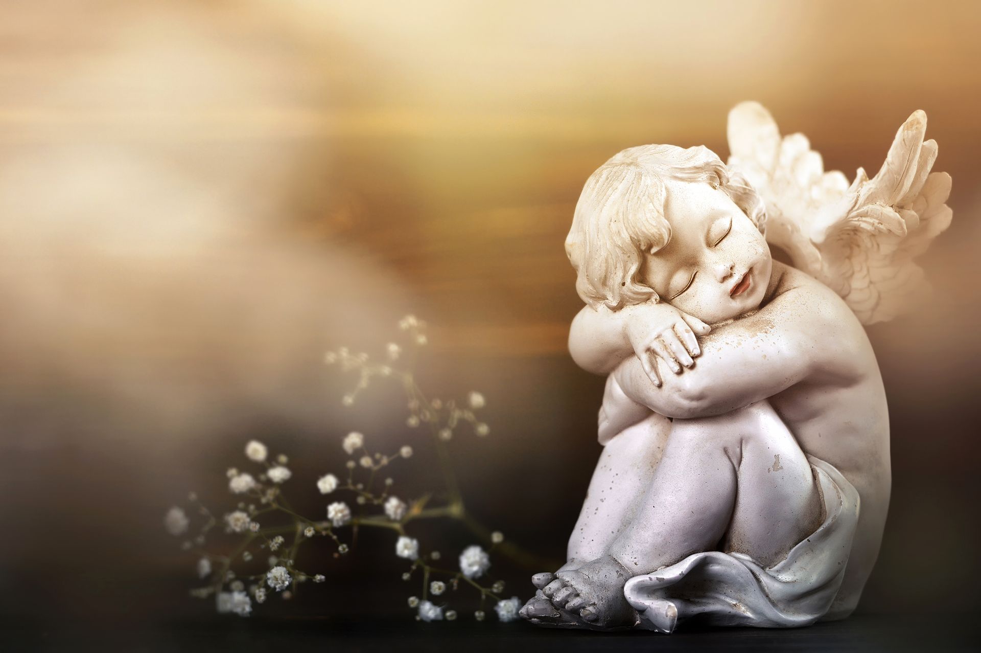 Una statua di un angelo dorme a terra.