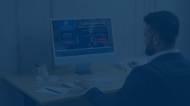 Man in suit using a computer, looking at a website on a desk.