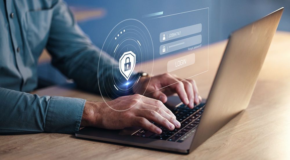 Person typing on laptop, overlaid with digital security elements, suggesting online login with a lock icon.
