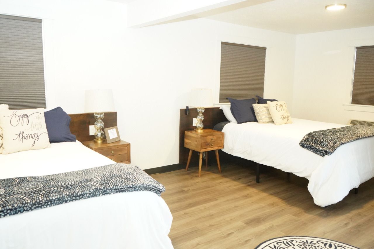 a bedroom with two beds and a rug on the floor .