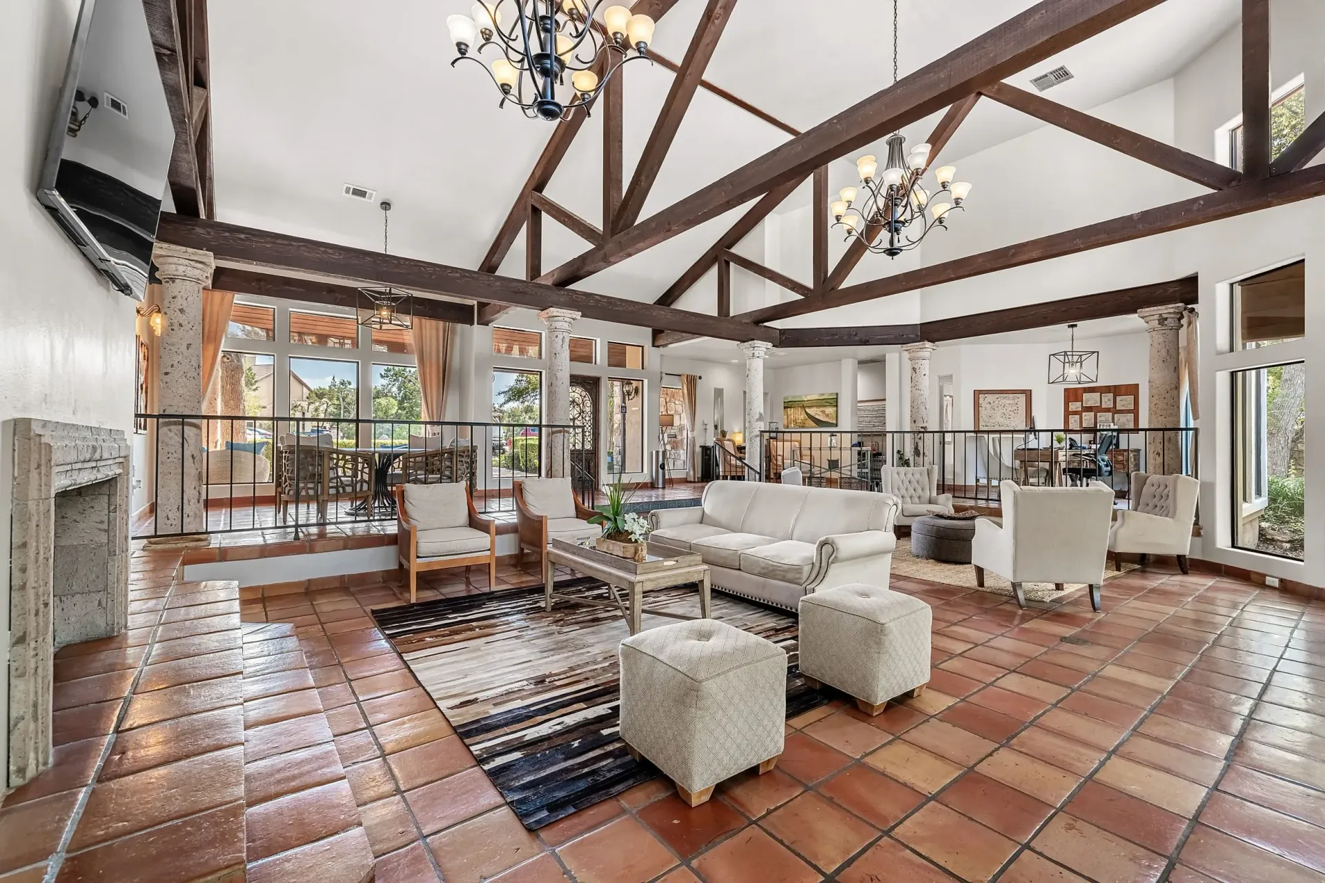 Spacious communal lounge area with a fireplace, comfortable seating, and large windows overlooking an outdoor patio.