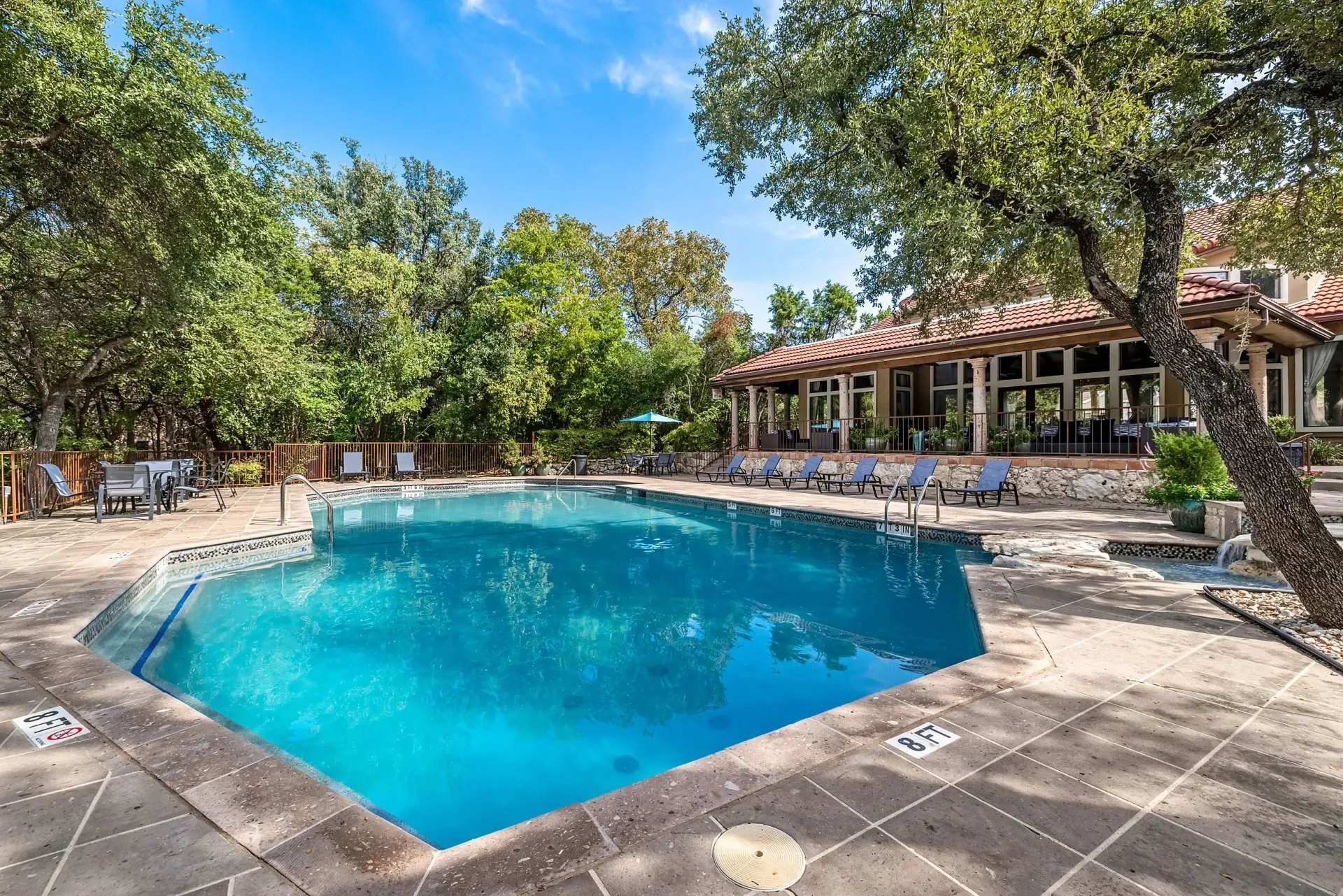 Resort-style swimming pool with lounge chairs and a clubhouse.