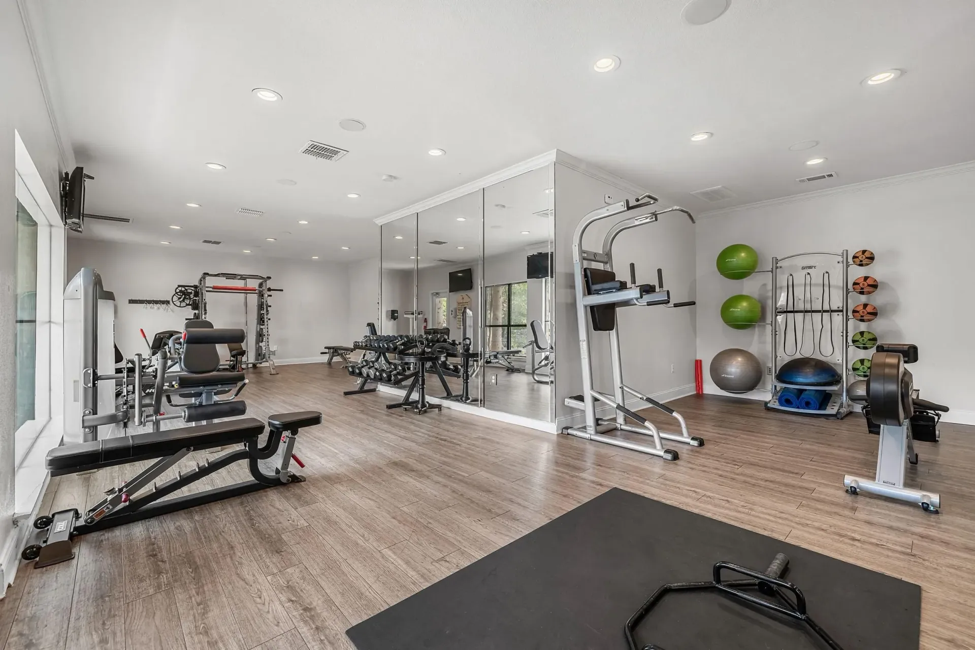 Well-equipped fitness center with cardio machines, weight machines, free weights, and exercise balls.