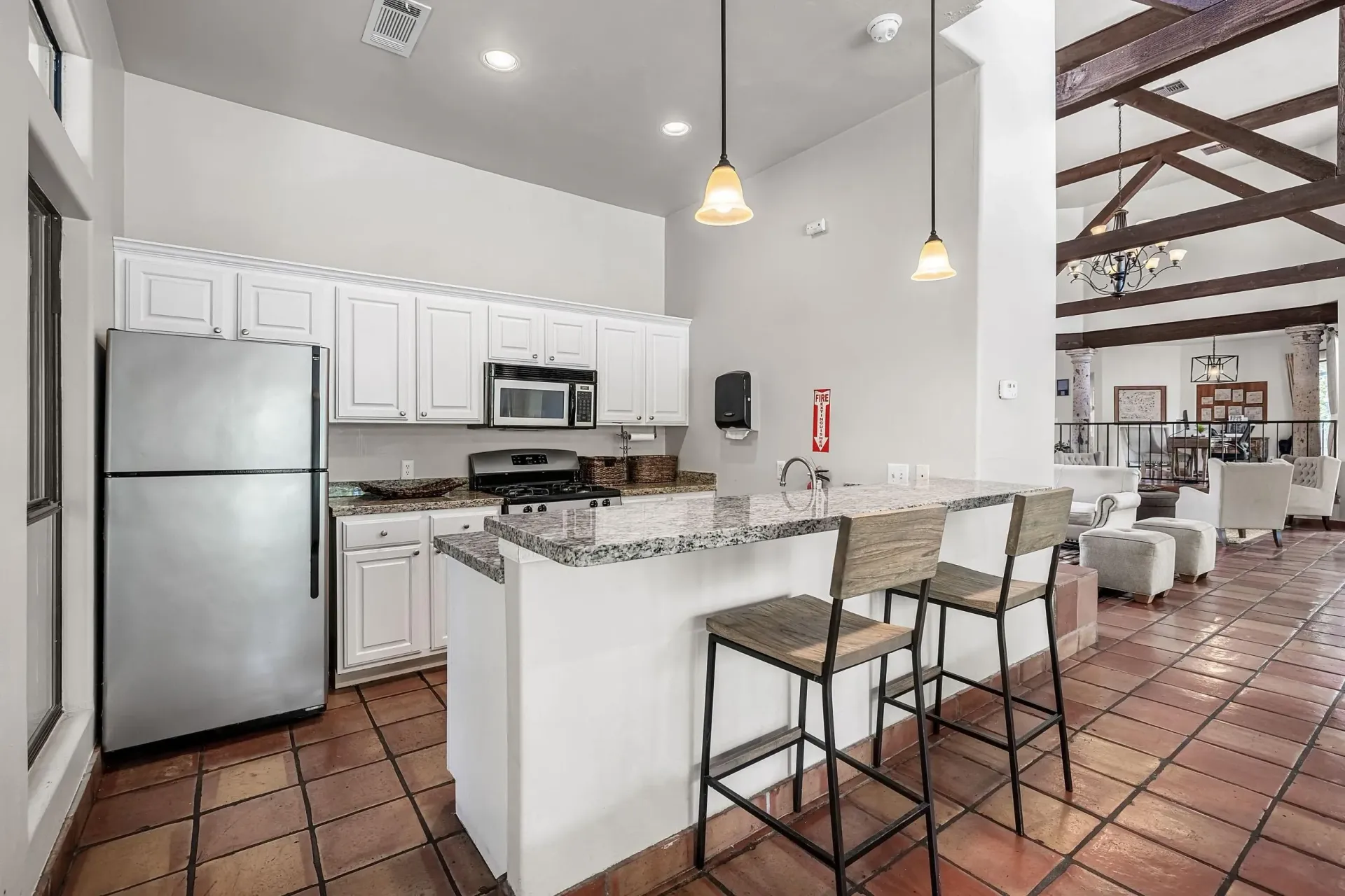 Kitchen area with island and seating in community lounge.
