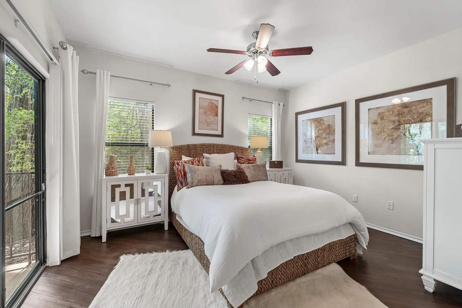 Bedroom with queen-size bed, sliding glass door, and decorative artwork.