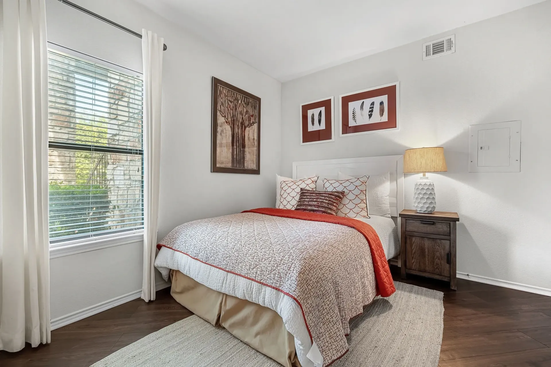 Cozy bedroom with a queen-sized bed, bedside table, and large window.