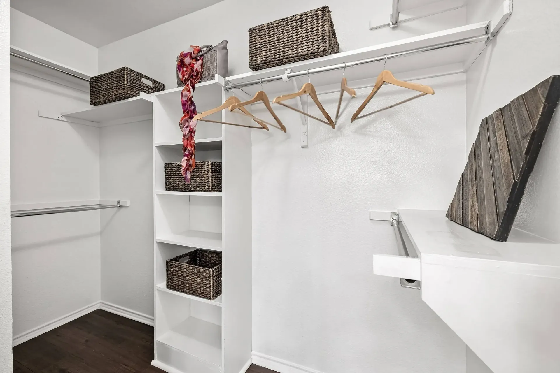 Walk-in closet with shelving, hanging rods, and baskets.