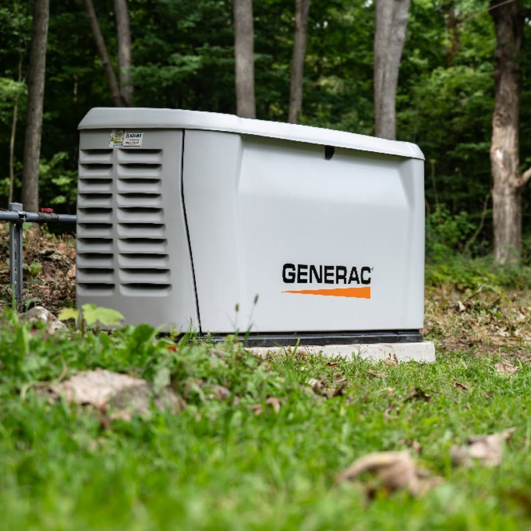 Gray Generac generator outdoors on a concrete pad in a wooded yard