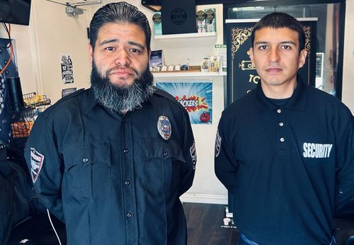 Two security guards are standing next to each other in a room
