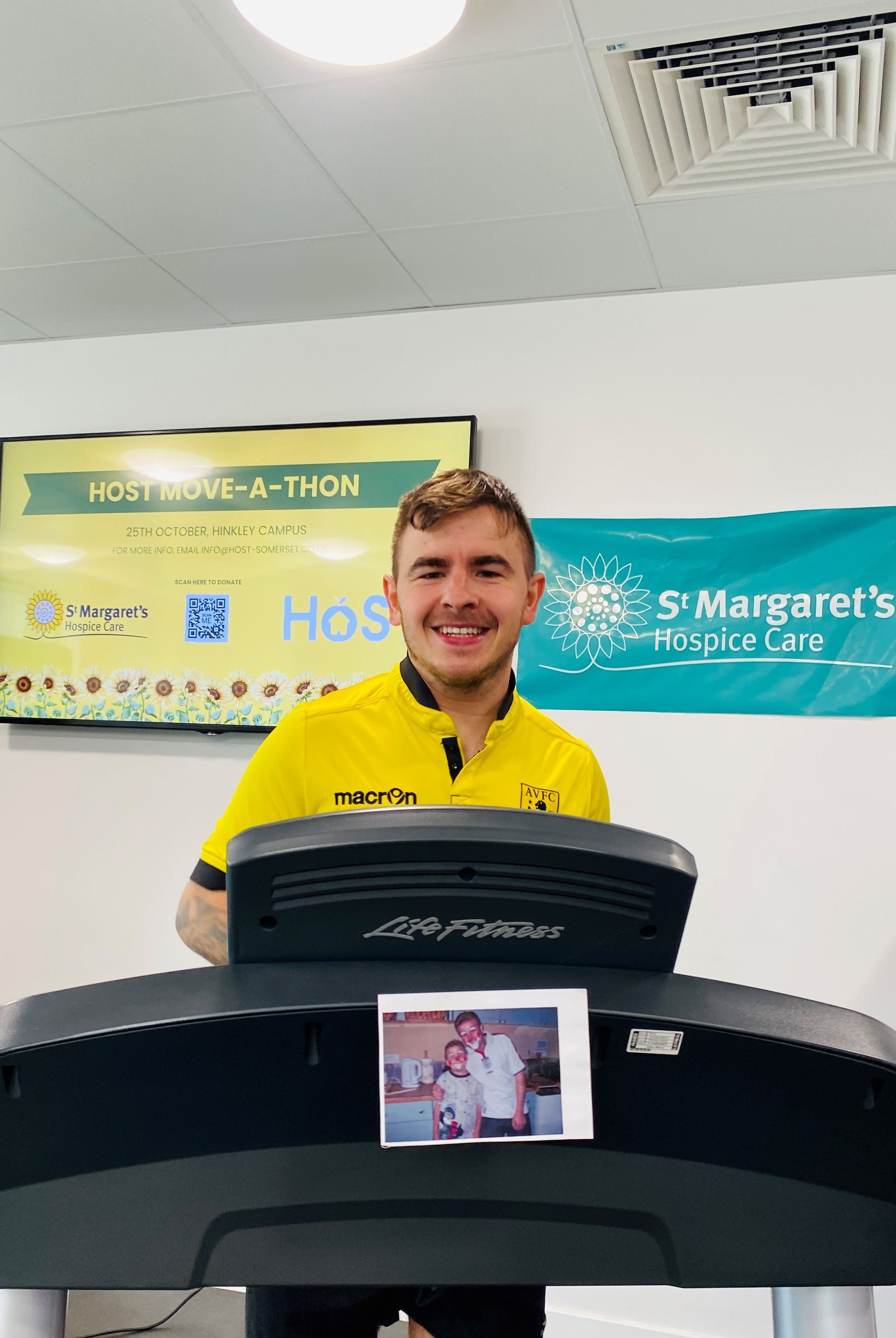 a man on a treadmill in front of a sign that says host move-a-thon