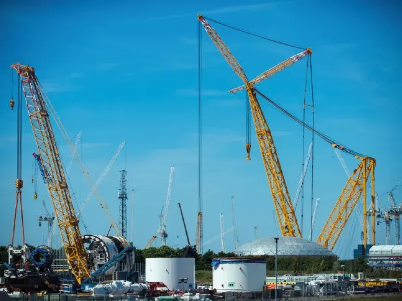 A construction site with a lot of cranes and tanks.