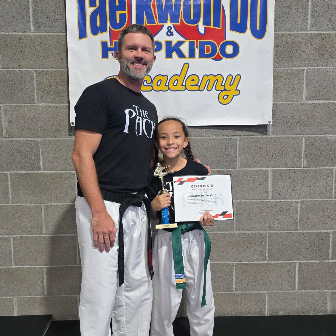 Student receiving martial arts achievement certificate