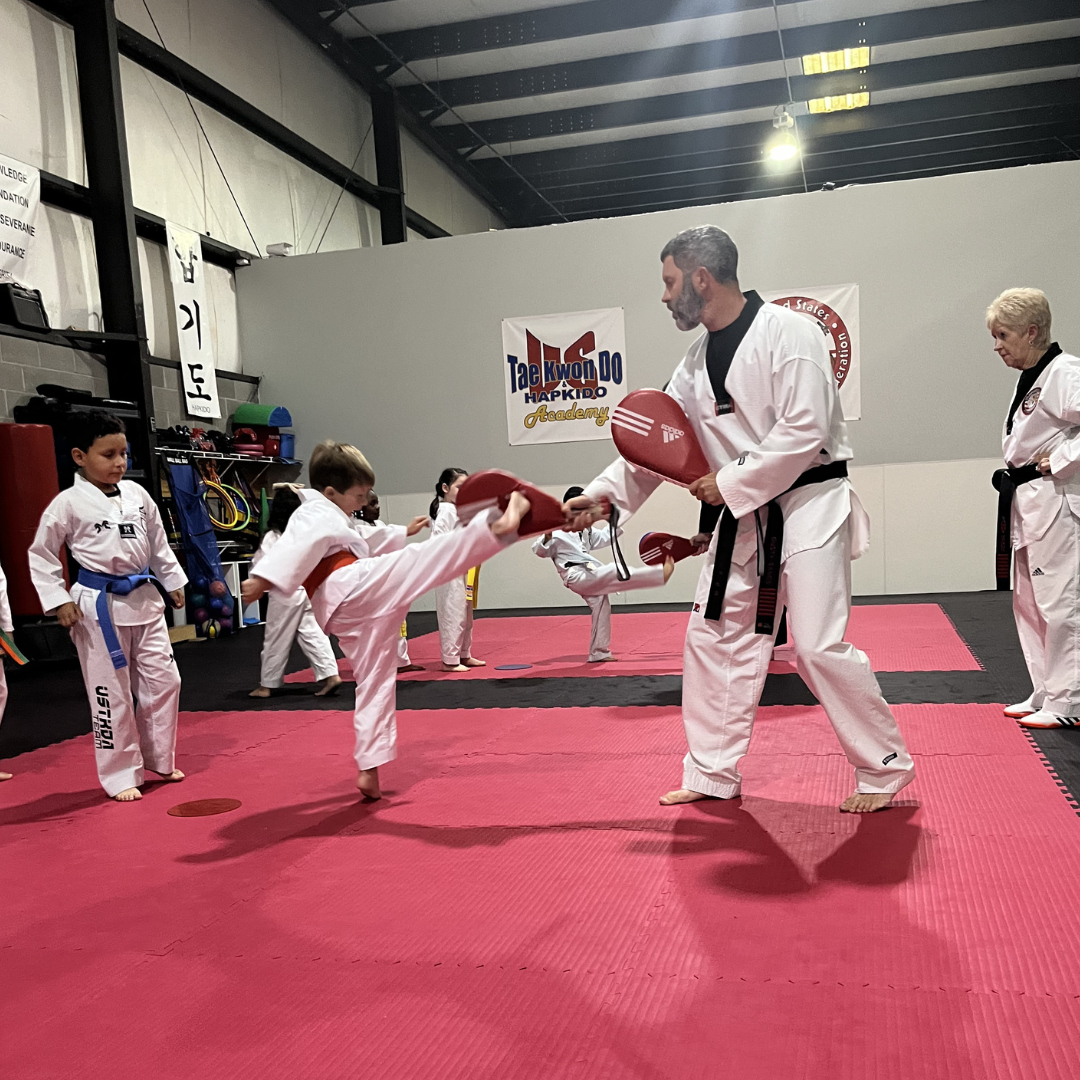 Children practicing Taekwondo target kicking with Master Dustin Sands at Tennessee Taekwondo in Mt. Juliet, TN