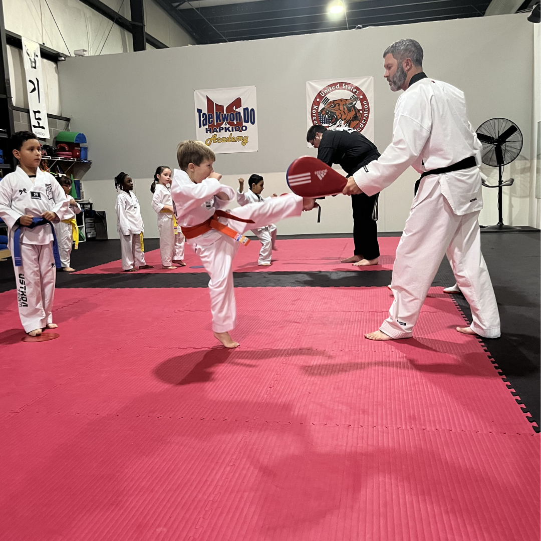 Young martial arts student practicing a kicking drill