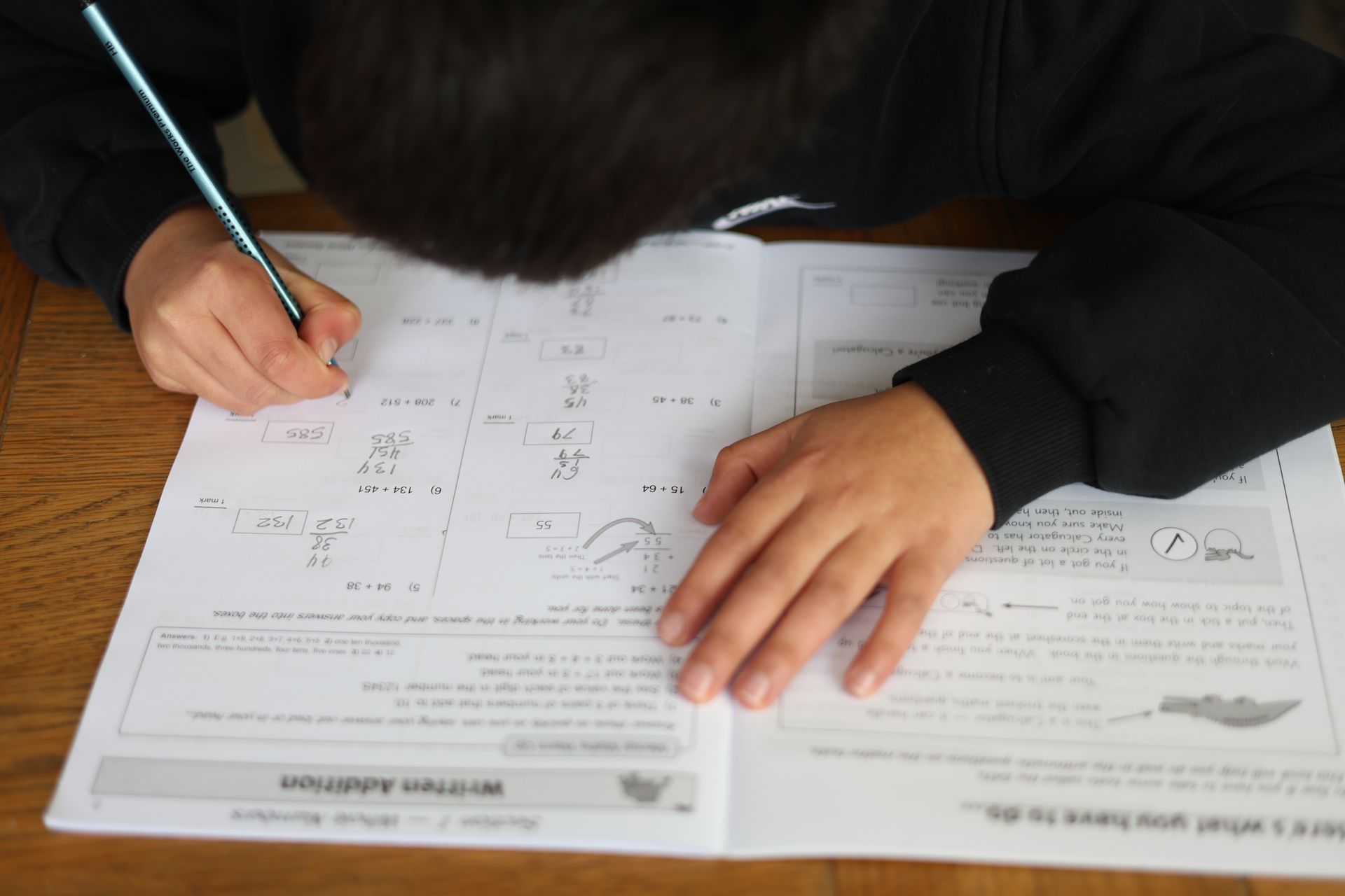 A person is writing on a piece of paper with a pen