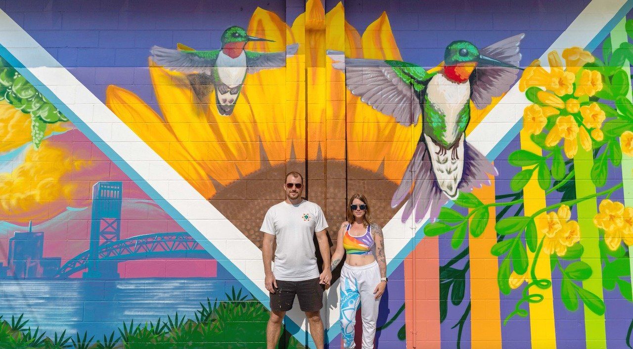 Spray Painted mural located in Riverside Jacksonville, Florida. Features bright vibrant colors, and natural subject matter like leaves, hummingbird, bee, and sunflower.