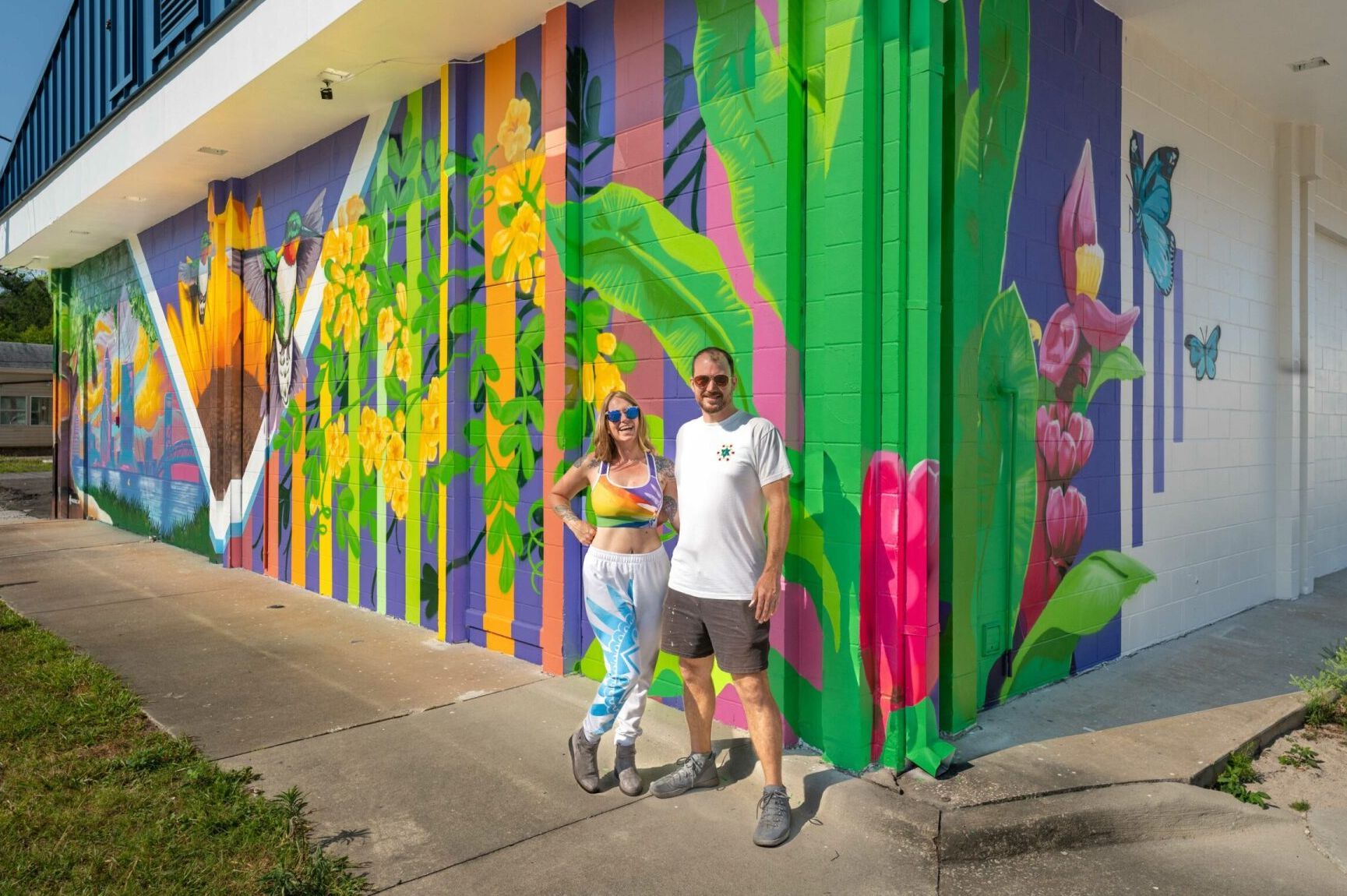 Spray Painted mural located in Riverside Jacksonville, Florida. Features bright vibrant colors, and natural subject matter like leaves, hummingbird, bee, and sunflower.