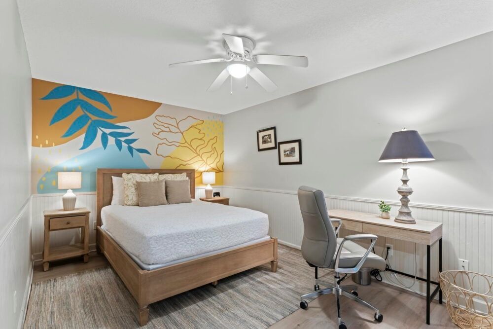 This hand painted acrylic accent wall was created for a short term rental located in palm coast, central beach, St. Augustine Florida. It features an abstract yellow, gold, and blue background with artistic lines and a blue leaf on top.