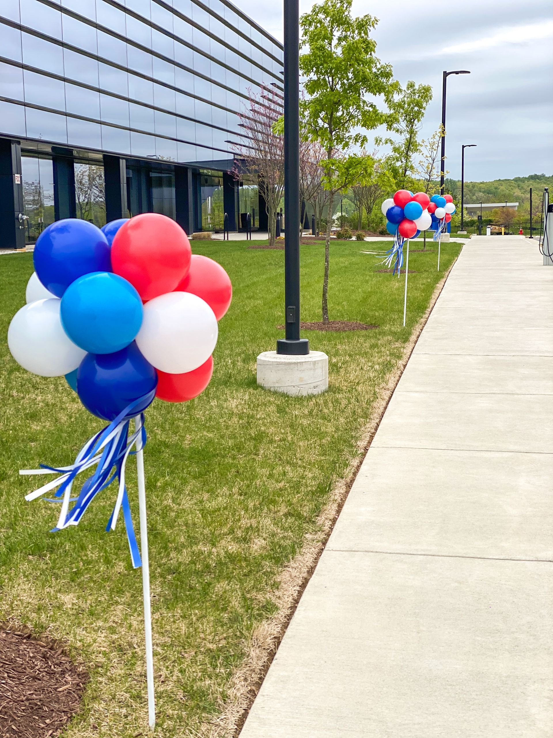 A bunch of red white and blue balloons on sticks