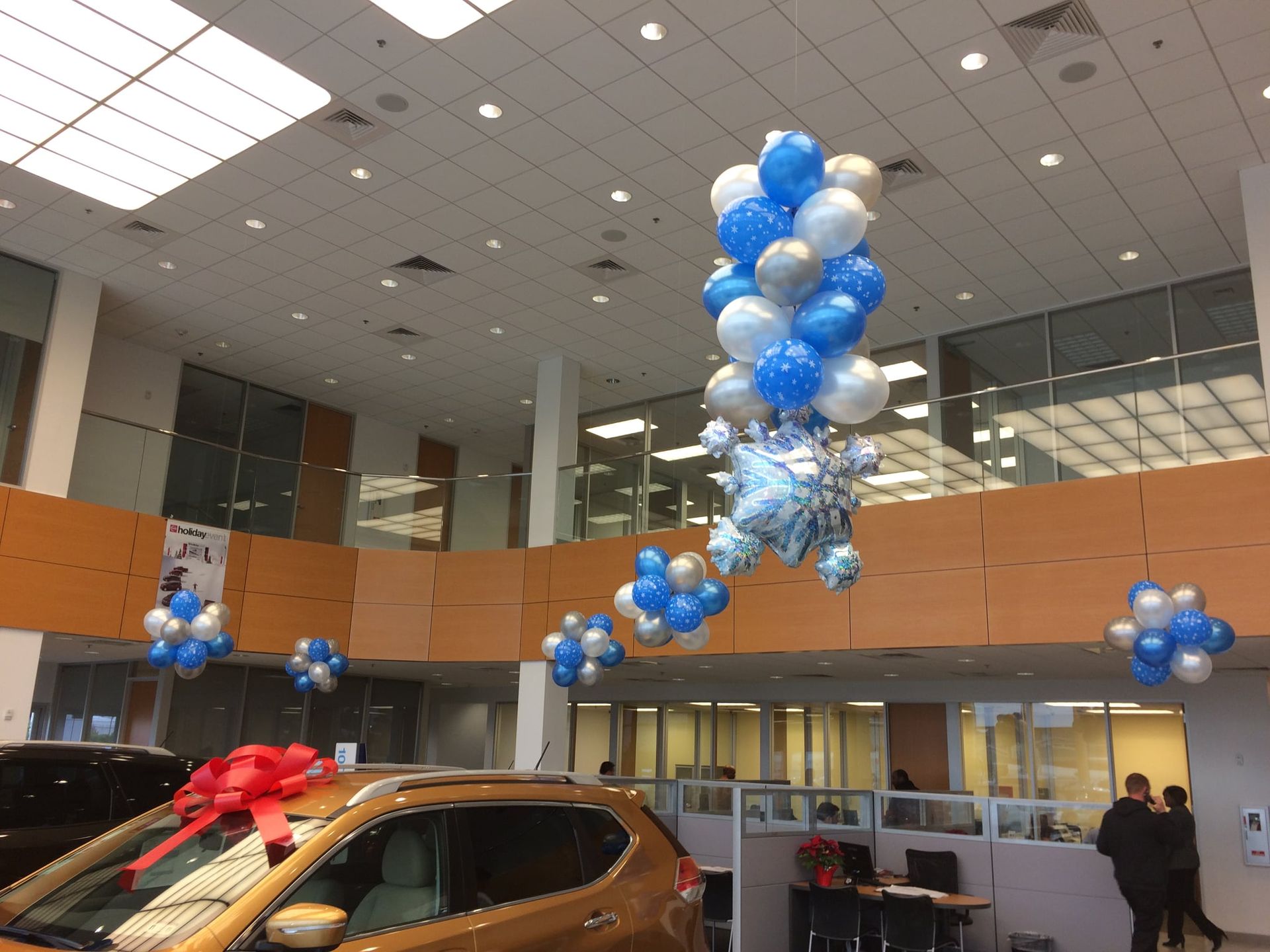 A car dealership with balloons hanging from the ceiling