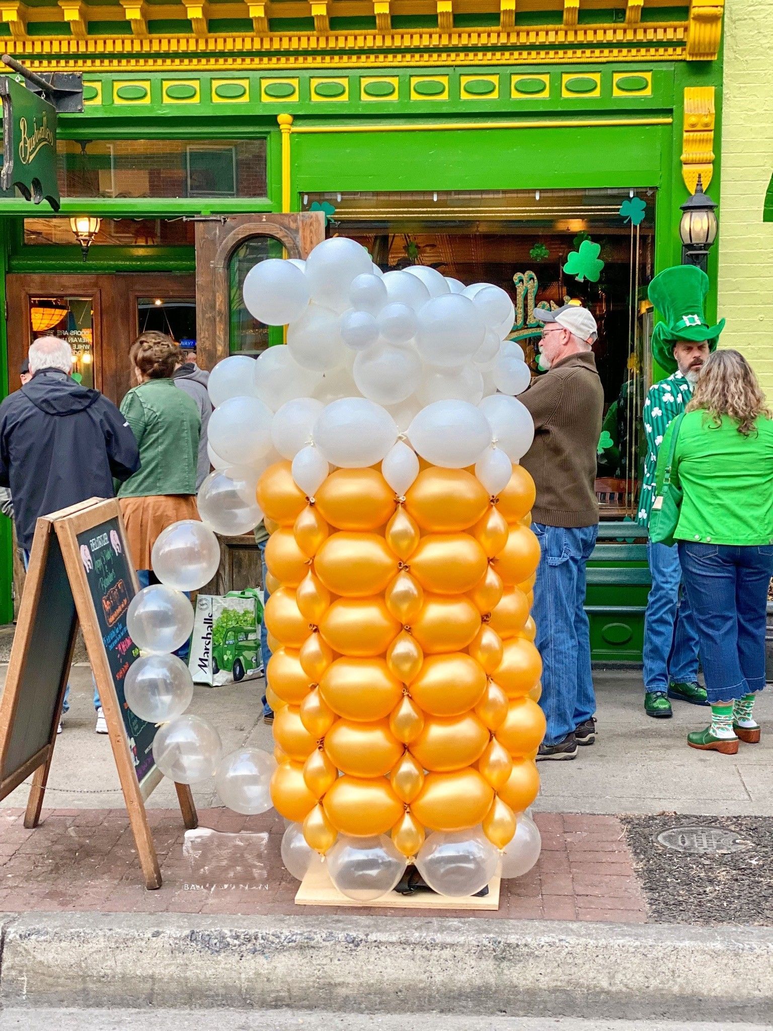 A beer glass made out of balloons is sitting in front of a restaurant.