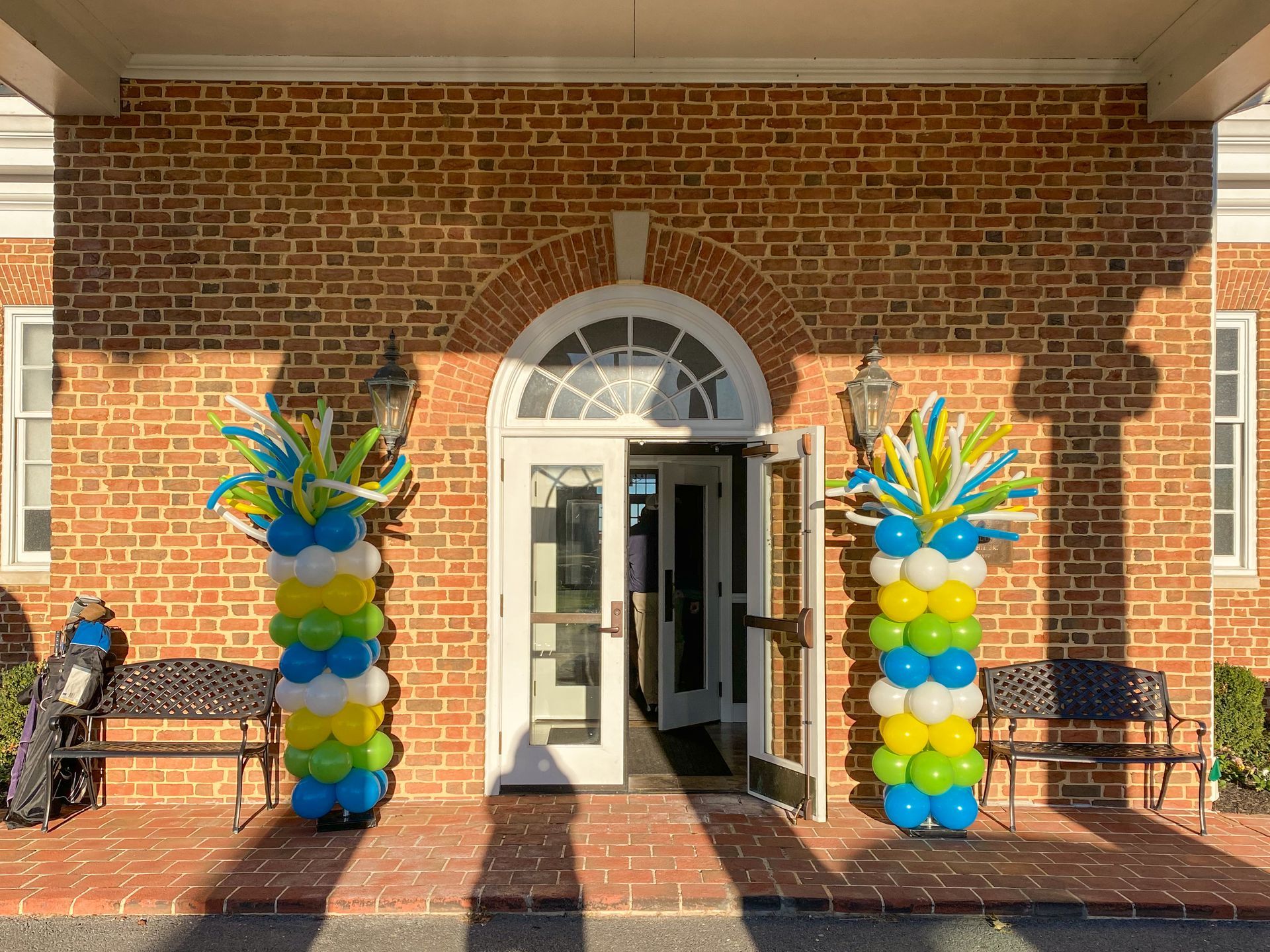 A brick building with balloons in the shape of pineapples in front of it.