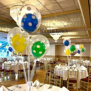 A room filled with tables and chairs decorated with balloons.