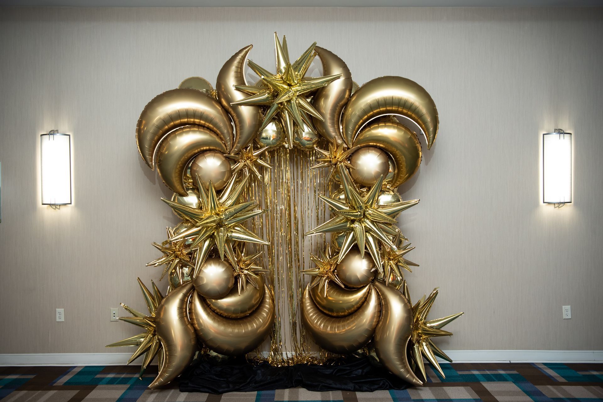 A bunch of gold balloons are sitting on the floor in a room.