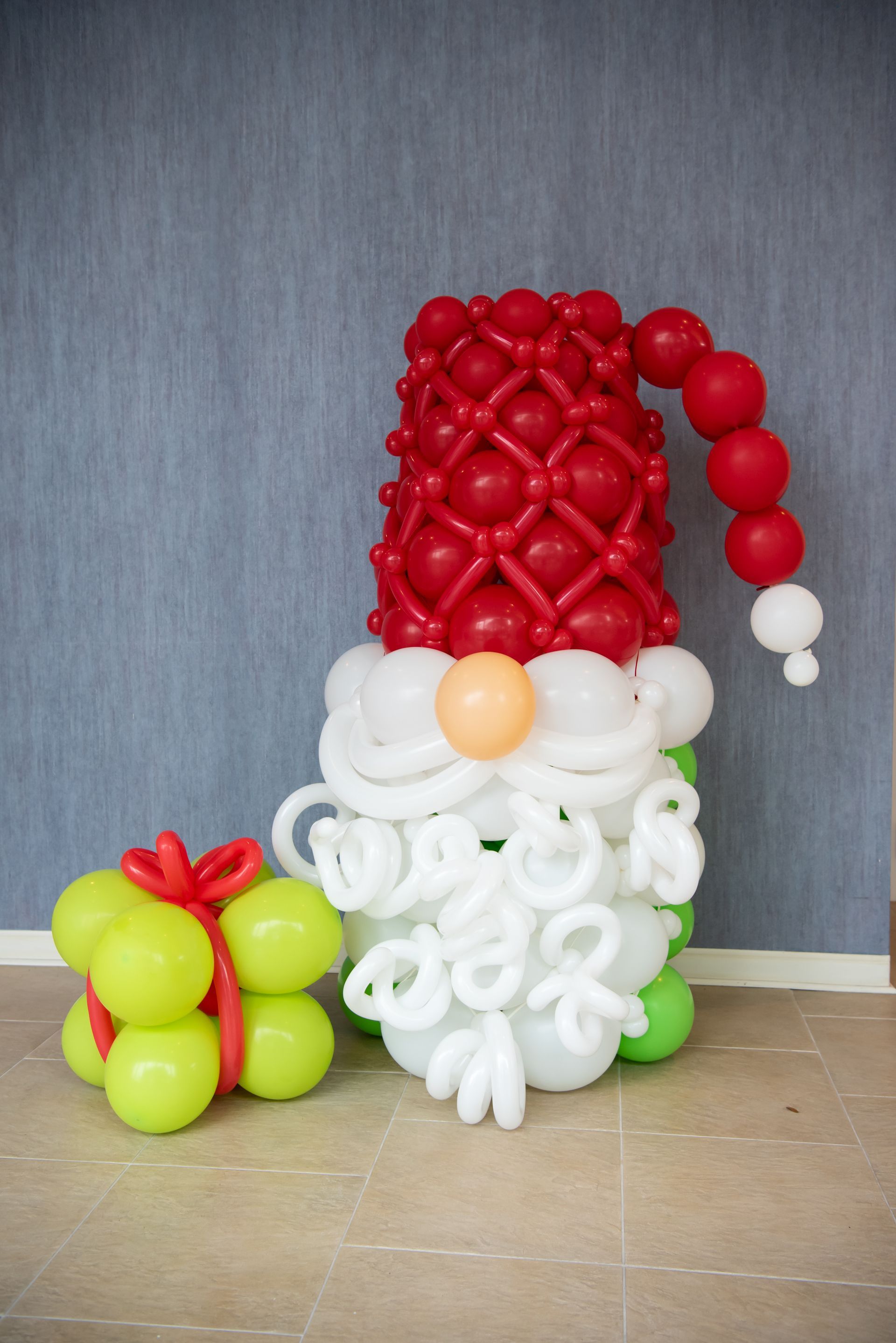 A gnome made out of balloons with a red hat and beard.
