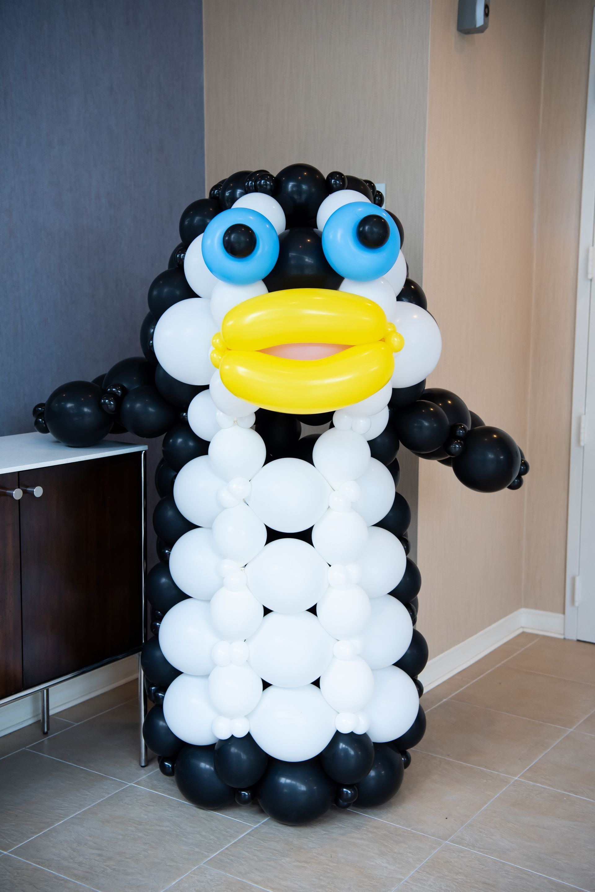 A penguin made out of balloons in a room