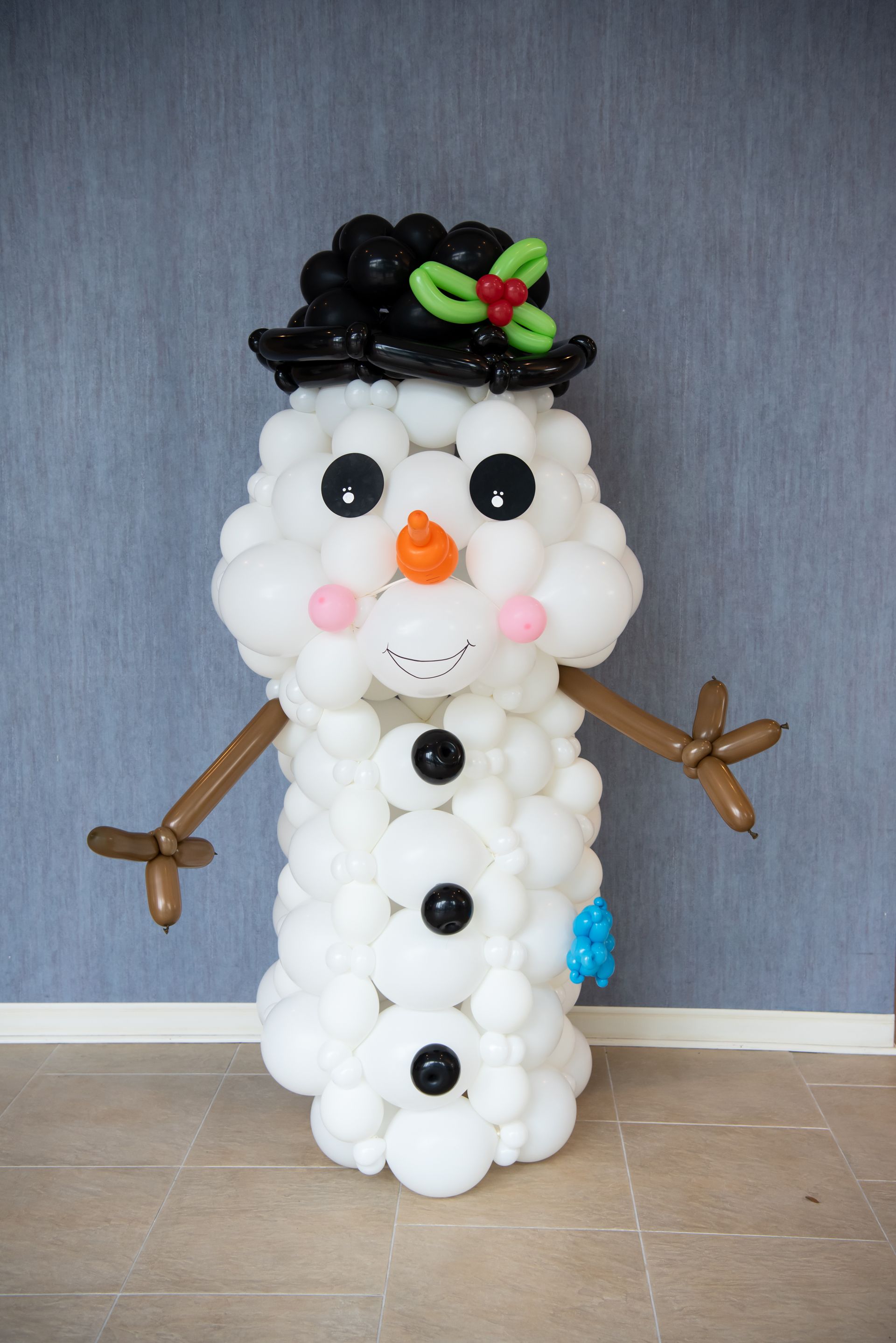 A snowman made out of balloons is standing in a room.
