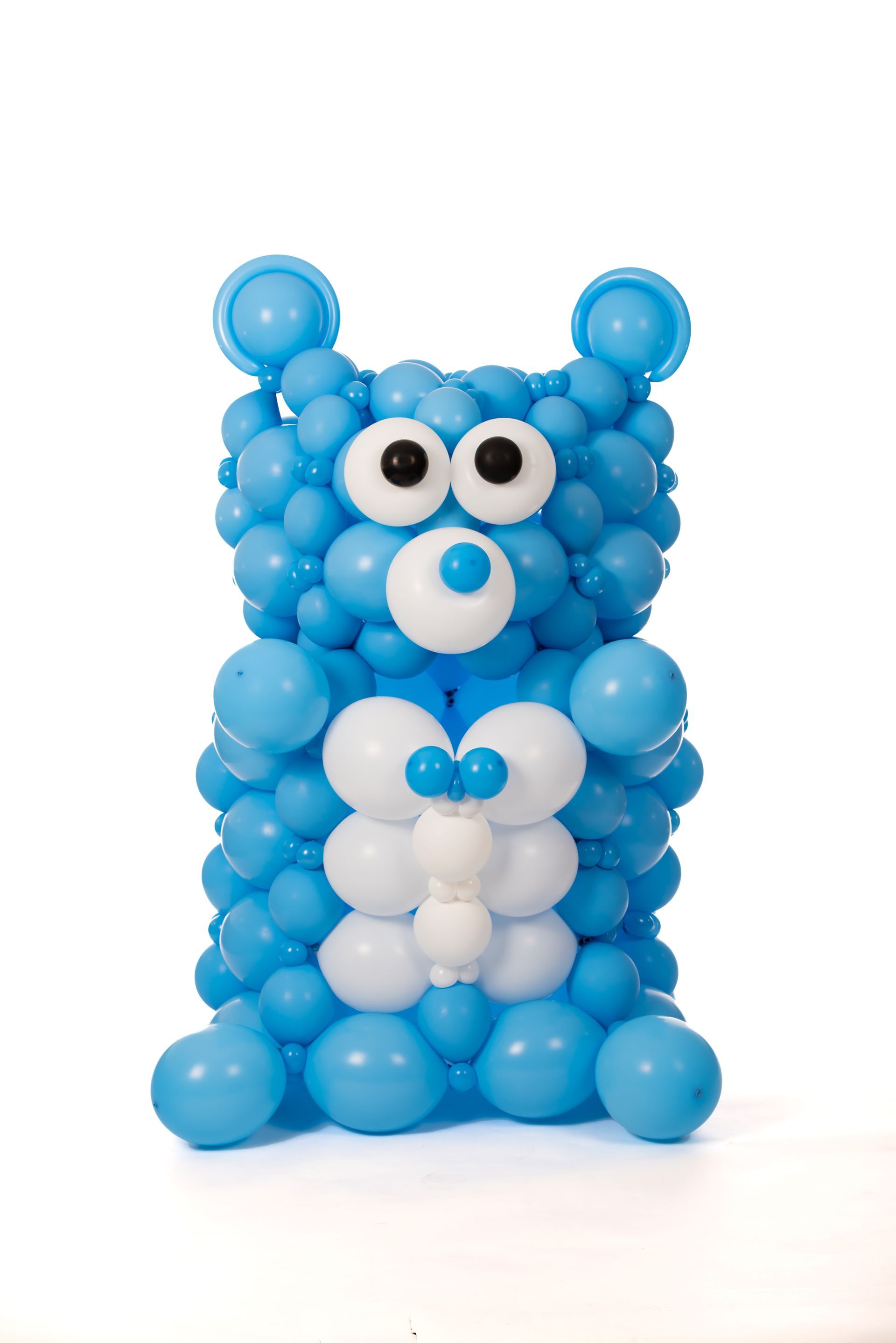 A teddy bear made out of blue and white balloons