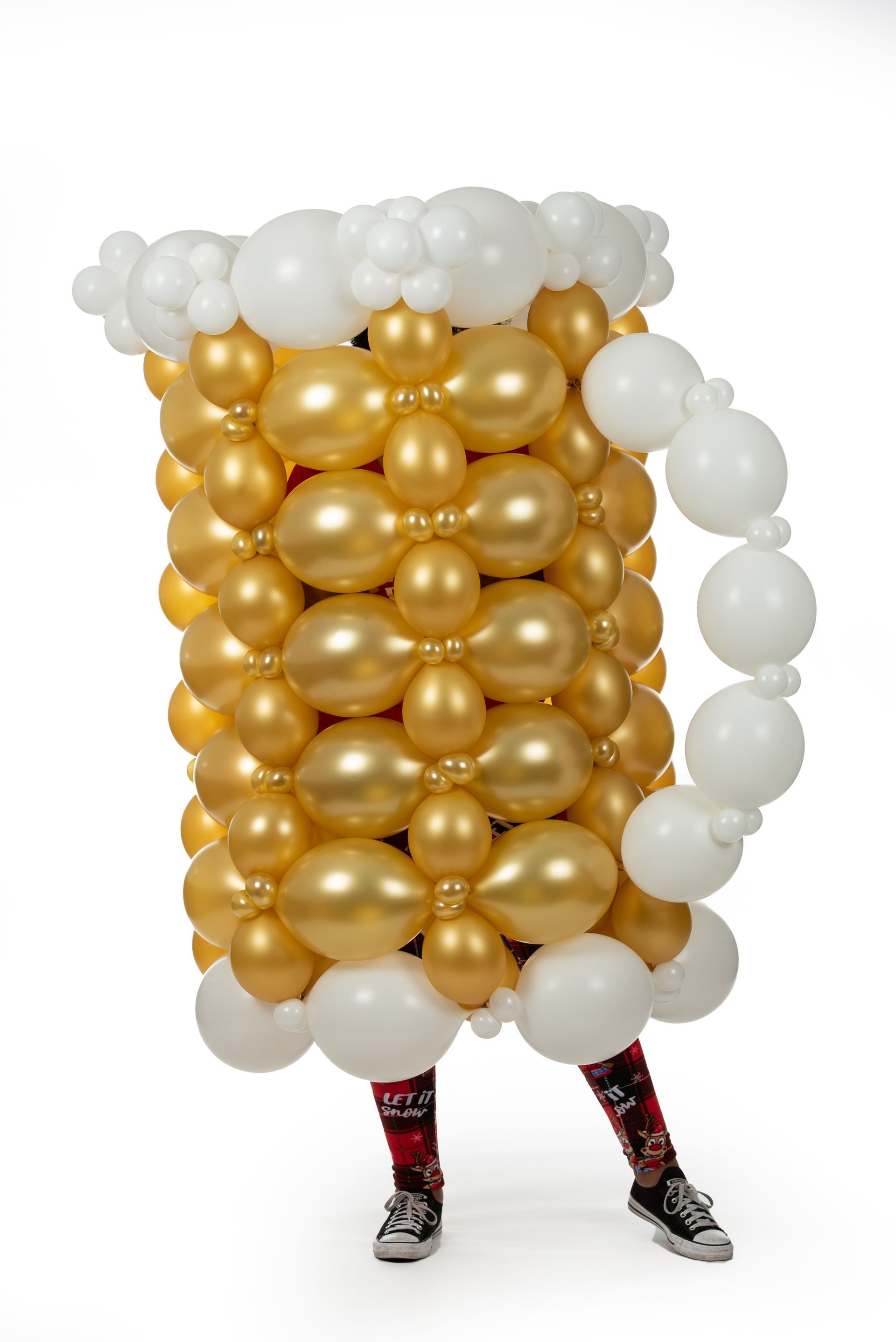 A person is dressed as a beer mug made of balloons.
