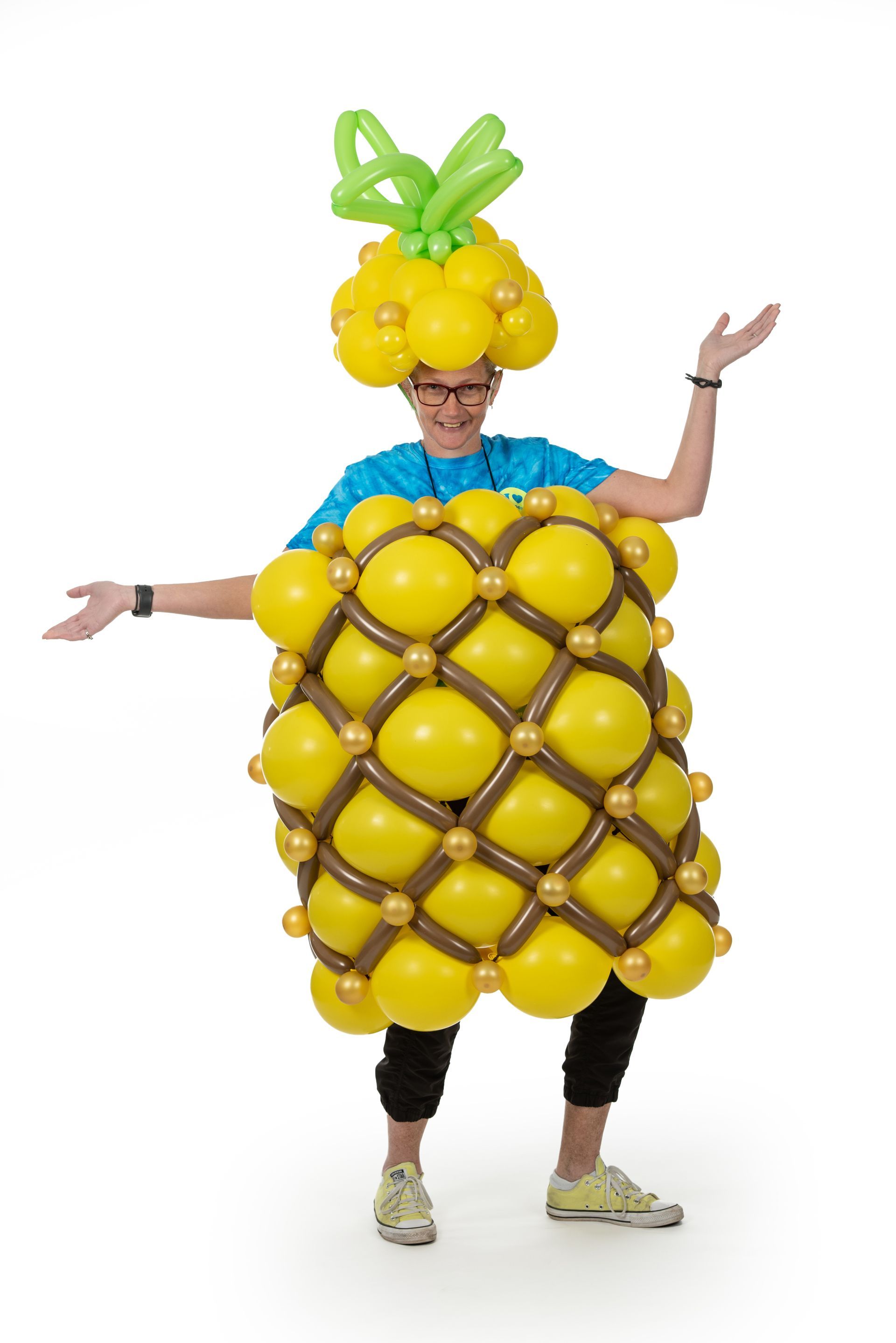 A man is dressed in a pineapple costume made of balloons