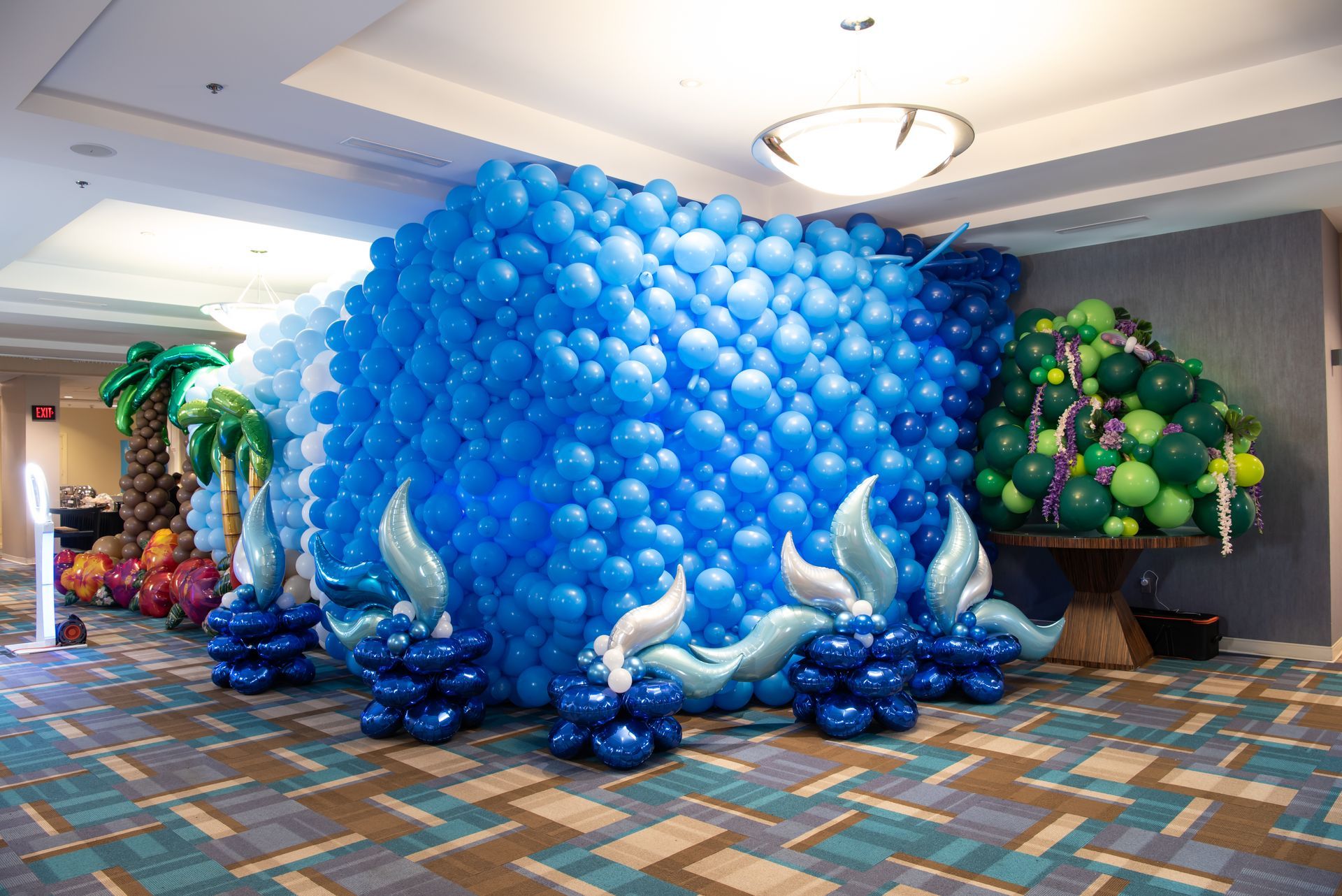 A room filled with lots of blue and green balloons.