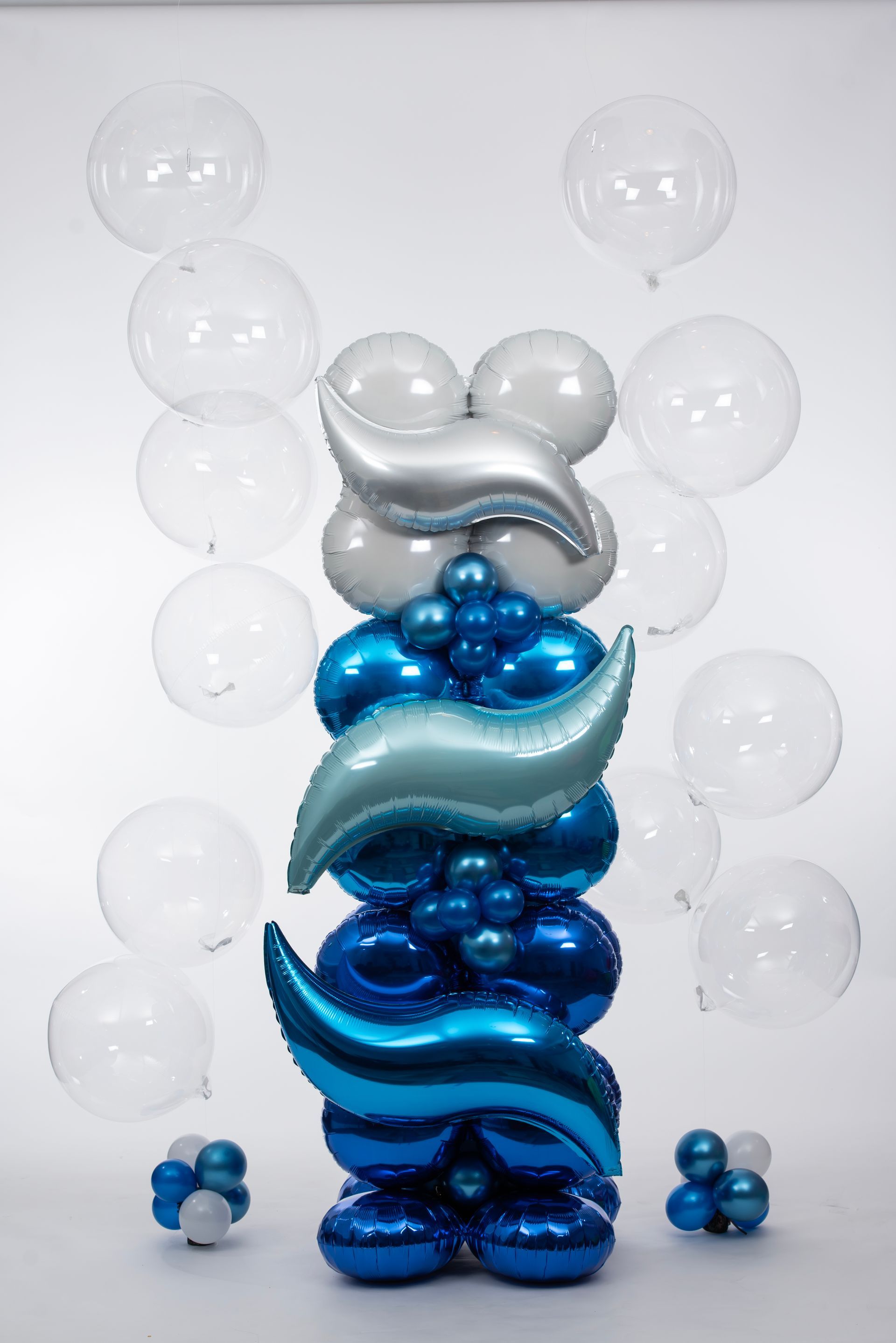A bunch of blue and white balloons are stacked on top of each other.