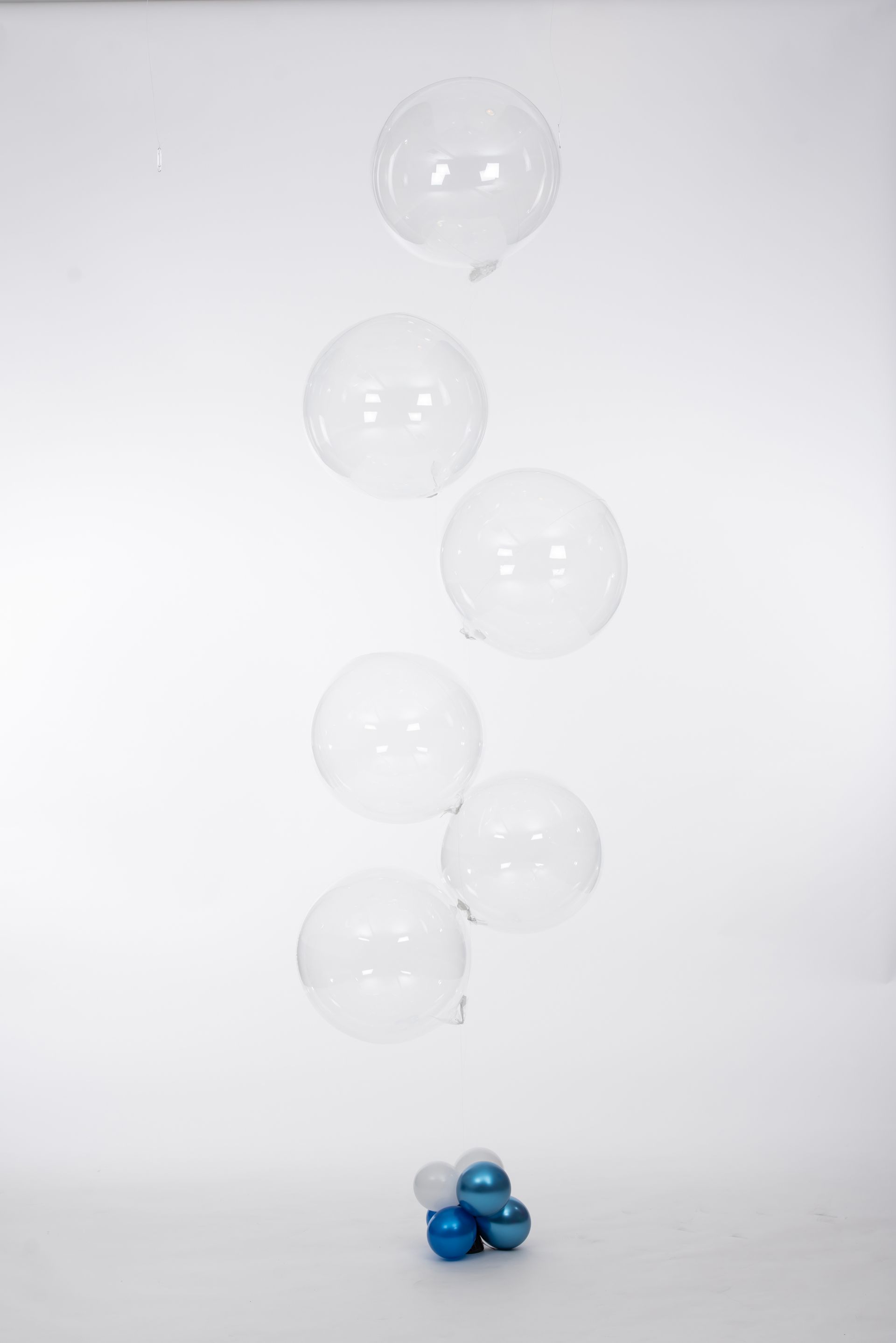 A bunch of clear balloons are floating in the air